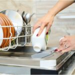 woman washes the dishes in the dishwashing machine.