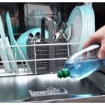Man filling dishwasher with gloss liquid