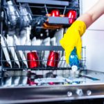 Woman filling dishwasher with gloss liquid.