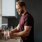 Why Is My Brita Filter So Slow? (Can I Speed It Up?) man pouring water in the jug from a tap